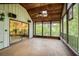 Spacious screened porch with tile flooring, a ceiling fan, and large windows offering stunning views of the surrounding greenery at 7470 Princeton Trce, Sandy Springs, GA 30328