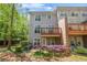Back exterior of townhome featuring a balcony, patio, manicured lawn, and brick accents at 1561 Mosaic Way, Smyrna, GA 30080