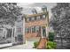 Beautiful brick townhome featuring a two-car garage and charming architectural details with stairs leading up to the front door at 1561 Mosaic Way, Smyrna, GA 30080