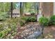Serene backyard with iron bench, lush landscaping, and a view of the home at 1826 Bedfordshire Ct, Decatur, GA 30033