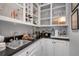 Convenient wet bar featuring upper shelving, counter space, sink, and white cabinetry at 1826 Bedfordshire Ct, Decatur, GA 30033
