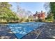 A large, covered swimming pool with an elegant brick house surrounded by mature landscaping at 3593 Hemphill St, Atlanta, GA 30337
