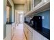 Butler pantry with white cabinets, black countertop, and stainless steel sink and decorative light fixture at 3593 Hemphill St, Atlanta, GA 30337