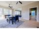 Open concept dining room featuring hardwood floors, large windows, ceiling fan, and transition to living room at 3593 Hemphill St, Atlanta, GA 30337
