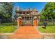 Stunning brick Victorian home with a turret, large porch, and wrought iron fence and gate with brick pillars at 3593 Hemphill St, Atlanta, GA 30337
