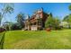 A large historic brick home with a turret has a sprawling front lawn dotted with mature trees and shrubbery at 3593 Hemphill St, Atlanta, GA 30337