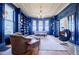 Spacious living room with dark blue walls, light wood floors, custom bookshelves and multiple windows at 3593 Hemphill St, Atlanta, GA 30337
