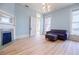 Inviting living room with light blue walls, hardwood floors, fireplace, and large windows at 3593 Hemphill St, Atlanta, GA 30337