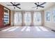 Sunlit living room boasts hardwood floors, built-in shelves, and elegant french doors to the outside at 3593 Hemphill St, Atlanta, GA 30337