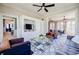 Inviting living room with built-in storage, ceiling fan, and hardwood floors, connecting to dining room at 3593 Hemphill St, Atlanta, GA 30337