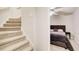 Staircase view leading to a bedroom featuring dark purple bedding and matching decor at 2121 Silva Ct, Conley, GA 30288