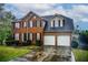 Charming two-story brick home with a two-car garage and well-manicured lawn at 2121 Silva Ct, Conley, GA 30288