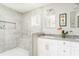 Bright bathroom featuring a tiled shower with a built-in bench and a double sink vanity with gray countertops at 2590 Hawthorne Ne Pl, Atlanta, GA 30345