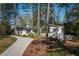 Aesthetic white brick home featuring a winding drive, mature landscaping, and multiple windows at 2590 Hawthorne Ne Pl, Atlanta, GA 30345