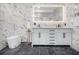 This bathroom features a modern vanity, marble wall and floor tile, and luxury lighting at 2806 Chaucer Sw Dr, Atlanta, GA 30311