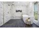 Modern bathroom featuring marble walls, a stand alone tub, and a glass shower at 2806 Chaucer Sw Dr, Atlanta, GA 30311