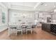 Dining room open to kitchen with modern chandelier, brick accent wall, and abundant natural light at 4025 Connolly Ct, Roswell, GA 30075