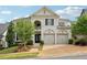 Charming two-story home boasts a brick facade, arched garage doors, and lush landscaping at 4025 Connolly Ct, Roswell, GA 30075