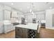 Gourmet kitchen featuring white cabinets, stainless appliances, large island, and wine storage at 4025 Connolly Ct, Roswell, GA 30075