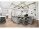 Open-concept living room with coffered ceilings, stone fireplace, and view into a modern kitchen at 4025 Connolly Ct, Roswell, GA 30075