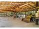 Interior view of an open barn structure with farm equipment stored inside at 700 Stewart Rd, Covington, GA 30016