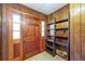 Inviting entryway featuring a wooden door, wood-paneled walls, and practical built-in shelving at 700 Stewart Rd, Covington, GA 30016