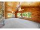 Bright living room with beautiful wood plank walls, carpet, and large windows overlooking the lawn at 700 Stewart Rd, Covington, GA 30016