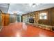 Finished basement area with wood paneled walls, retro flooring and a stone fireplace with stone hearth at 700 Stewart Rd, Covington, GA 30016