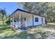 Charming single-story home with a covered porch and well-maintained landscaping on a sunny day at 21 W Lake Dr, Oxford, GA 30054