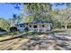 Scenic view of a charming single-story home with a covered porch surrounded by mature trees at 21 W Lake Dr, Oxford, GA 30054