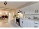 Modern kitchen featuring white cabinets, quartz countertops, and stainless steel oven with a black range hood at 21 W Lake Dr, Oxford, GA 30054