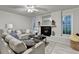 Comfortable living room with a fireplace, large sofa, and ample natural light, creating a cozy ambiance at 21 W Lake Dr, Oxford, GA 30054