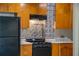 Kitchen showcases black appliances, light countertops, a tile backsplash, and wooden cabinets at 2285 Peachtree Ne Rd # 604, Atlanta, GA 30309