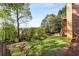 A grassy backyard with a view of the home's deck and surrounding trees at 482 Cooper Lake Se Rd, Smyrna, GA 30126