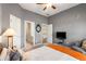 Well-lit bedroom featuring a ceiling fan, television, and a doorway to an en-suite bathroom at 482 Cooper Lake Se Rd, Smyrna, GA 30126