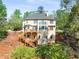 A full exterior view of the home with a deck, stairs, and well-manicured lawn at 482 Cooper Lake Se Rd, Smyrna, GA 30126