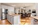 Open kitchen boasts stainless steel appliances, granite countertops, and large island with adjacent table and chairs at 482 Cooper Lake Se Rd, Smyrna, GA 30126