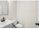 Elegant half-bathroom with a pedestal sink, toilet, and sleek black hardware at 1016 Rose Dr, Marietta, GA 30060