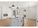Modern kitchen island with a sink, stainless steel dishwasher, and view of the open living space at 1016 Rose Dr, Marietta, GA 30060