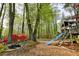Charming backyard featuring a custom built playground, mature trees, a small water feature, and colorful azaleas at 1039 Smyrna Rd Sw, Conyers, GA 30094