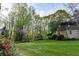 Backyard view with a shed, lawn, tall trees and bushes, providing a private retreat at 1039 Smyrna Rd Sw, Conyers, GA 30094