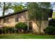 Well-manicured backyard featuring a brick house with mature trees, a lush lawn, and charming landscaping at 1039 Smyrna Rd Sw, Conyers, GA 30094