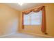 Modest bedroom with neutral walls and carpet, window with decorative curtain swag at 1039 Smyrna Rd Sw, Conyers, GA 30094