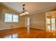 Dining room features hardwood flooring, a chandelier, and multiple windows with natural light at 1039 Smyrna Rd Sw, Conyers, GA 30094