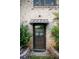Inviting front door featuring a brick facade, metal awning, and glass panels providing a warm welcome at 1039 Smyrna Rd Sw, Conyers, GA 30094