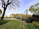Beautifully landscaped front yard with green lawn, mature trees, and flowering bushes at 1039 Smyrna Rd Sw, Conyers, GA 30094