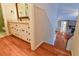 Hallway featuring hardwood floors and white cabinets leading to the living room and bathroom at 1039 Smyrna Rd Sw, Conyers, GA 30094