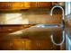 Close up shot of the kitchen sink featuring stainless steel fixtures, dark counters and backsplash at 1039 Smyrna Rd Sw, Conyers, GA 30094
