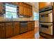 Kitchen with stainless steel appliances, wooden cabinetry, hardwood floors and a bright window at 1039 Smyrna Rd Sw, Conyers, GA 30094