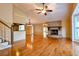 Spacious living room with hardwood floors, brick fireplace and ceiling fan with light at 1039 Smyrna Rd Sw, Conyers, GA 30094